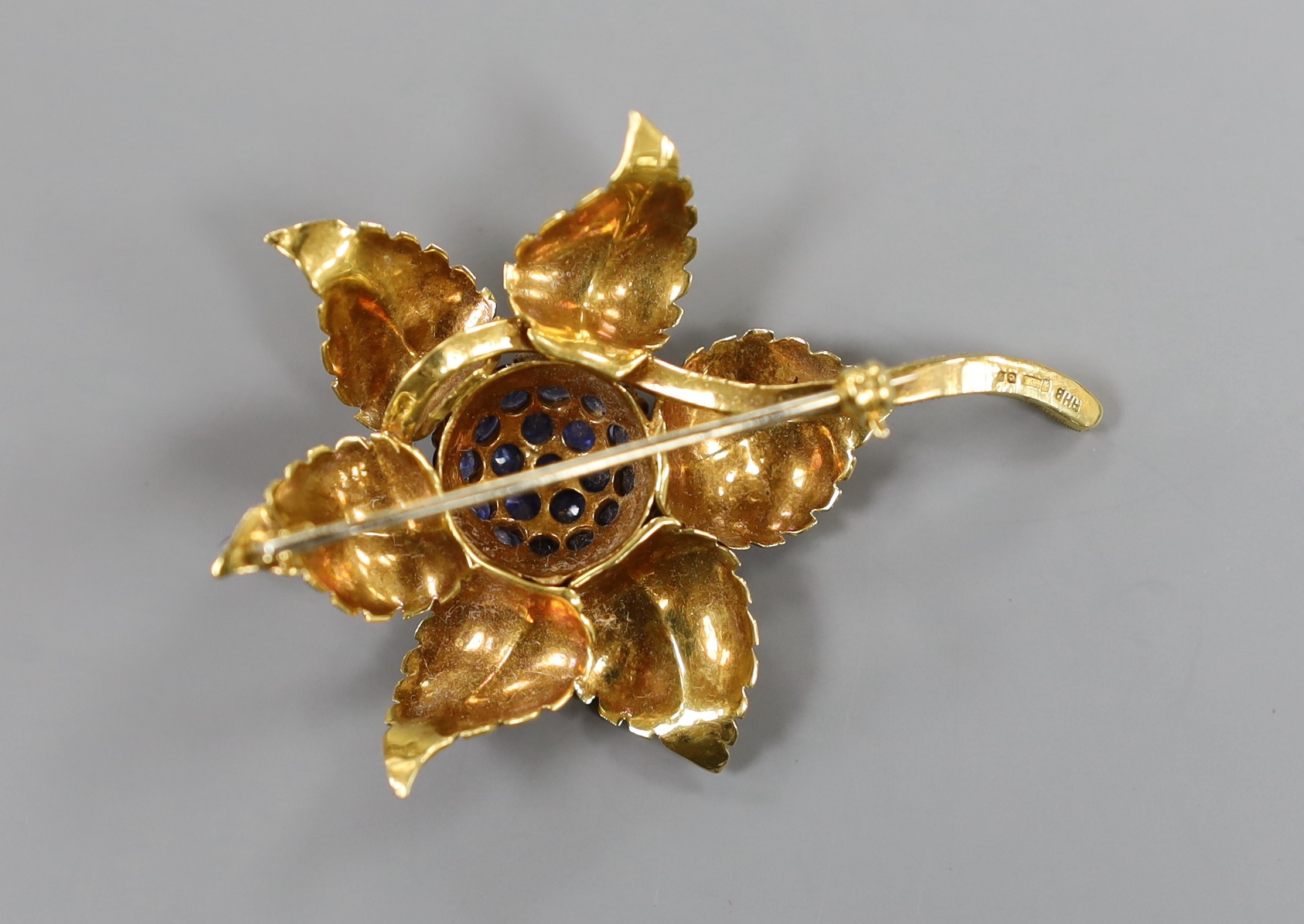 A modern 18ct gold and sapphire cluster set flower brooch, 55mm, gross weight 15.1 grams.